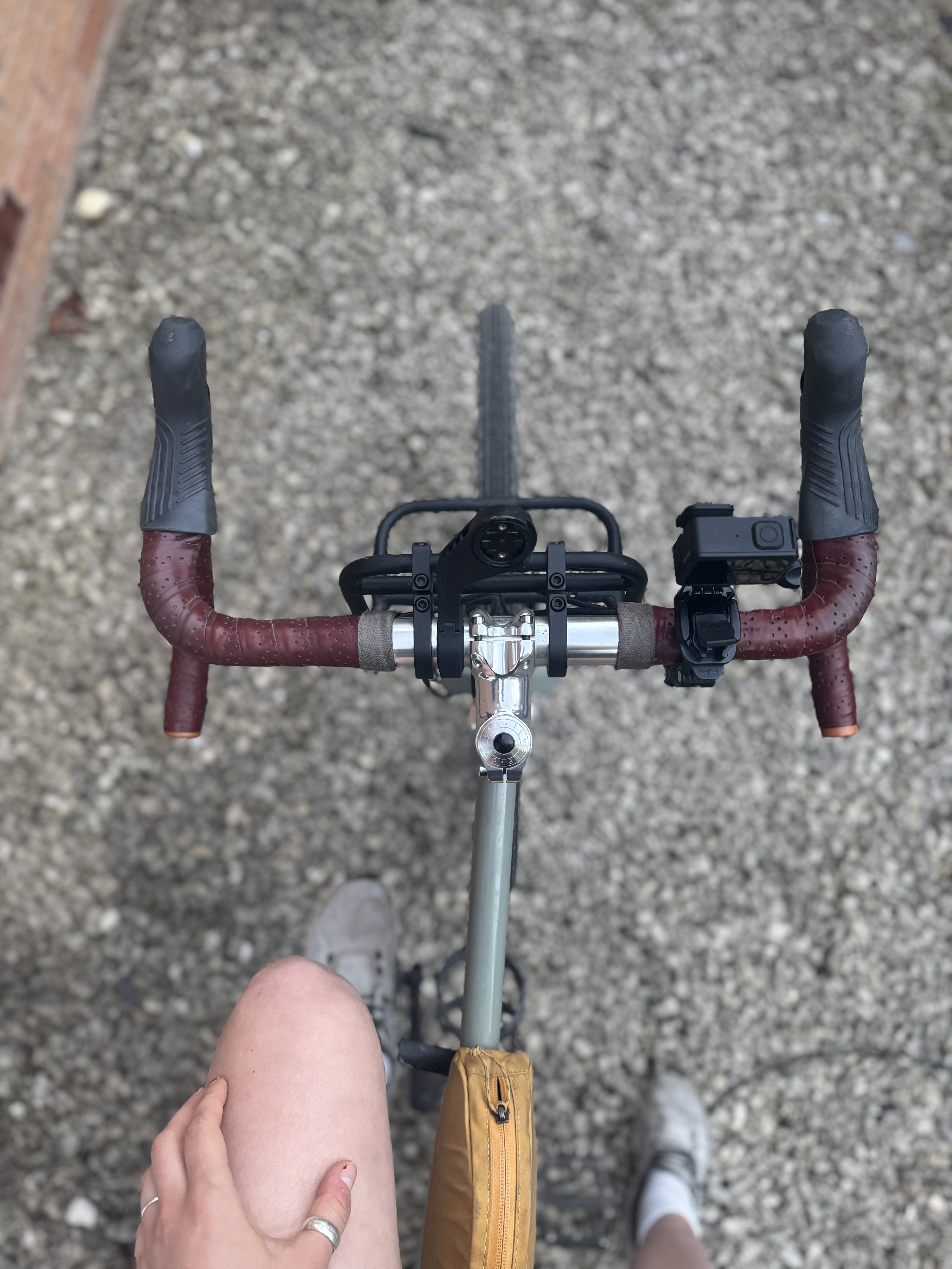 A small black camera on some bike handlebars