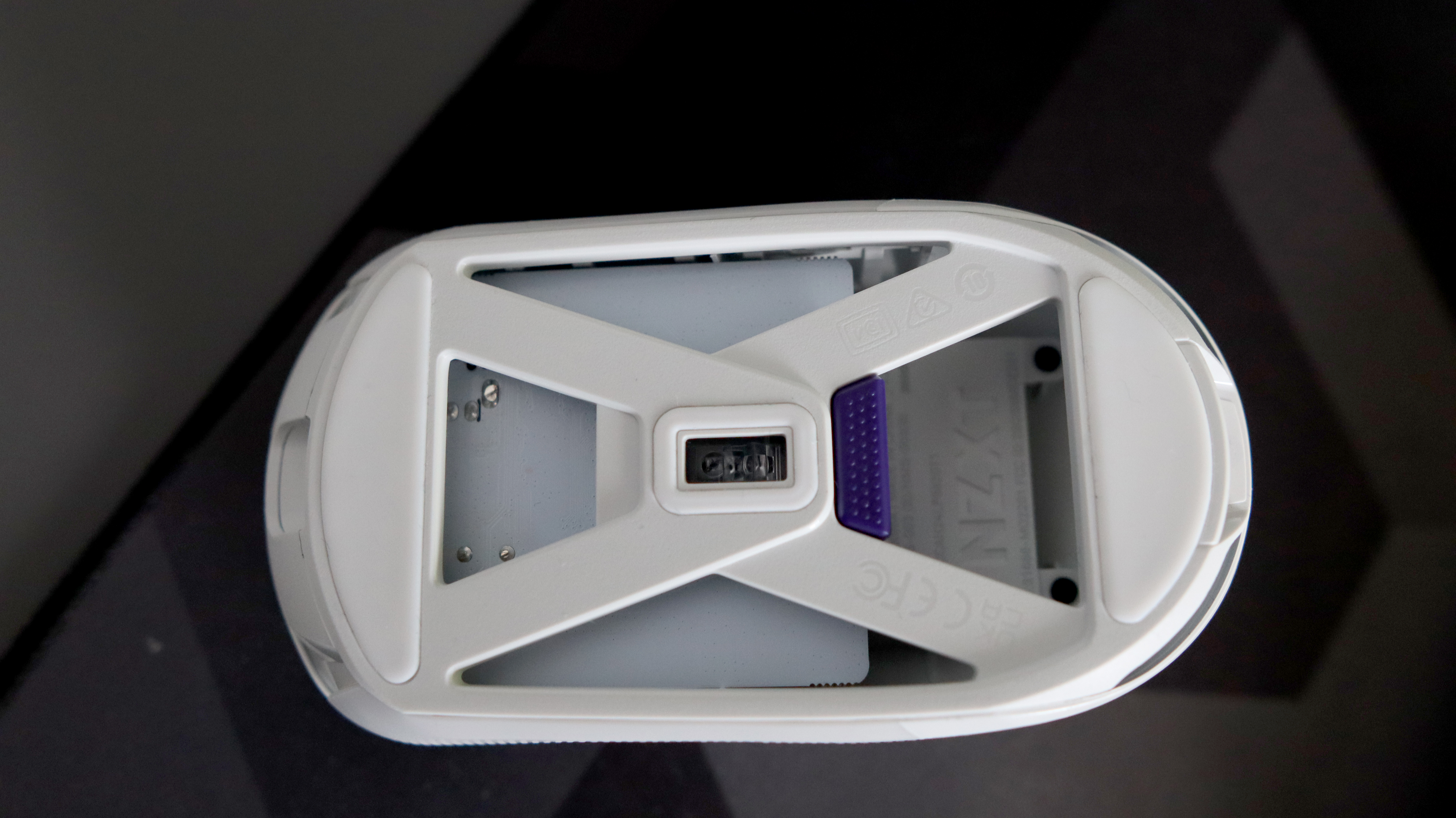 An NZXT Lift Elite Wireless gaming mouse in white set-up on a desk.