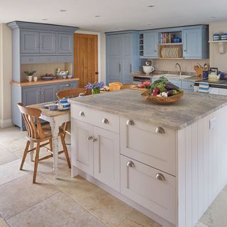 kitchen with marble flooring countertops and pastel cupboards