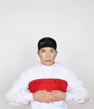 Marina Abramović in white with red band