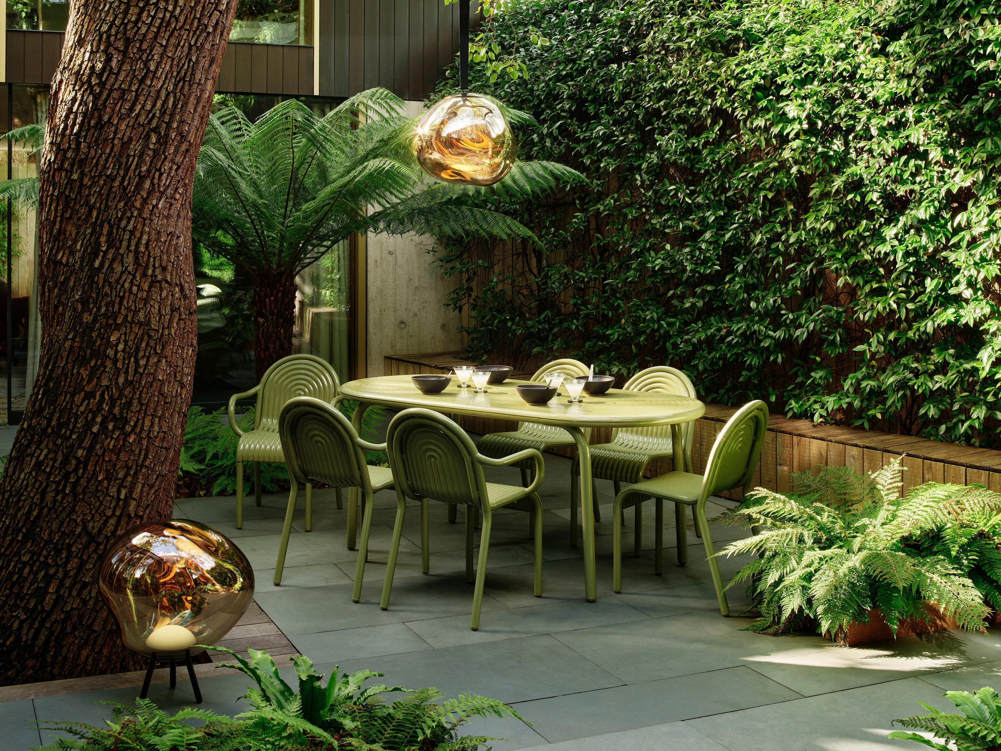 a green modern outdoor furniture set in a contemporary city garden