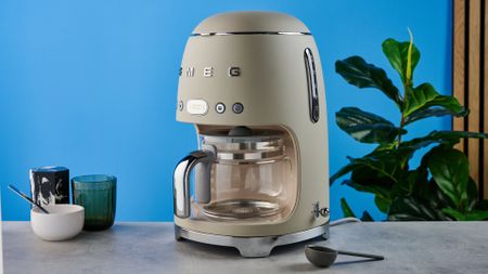 the smeg retro coffee maker photographed against the blue tom's guide background