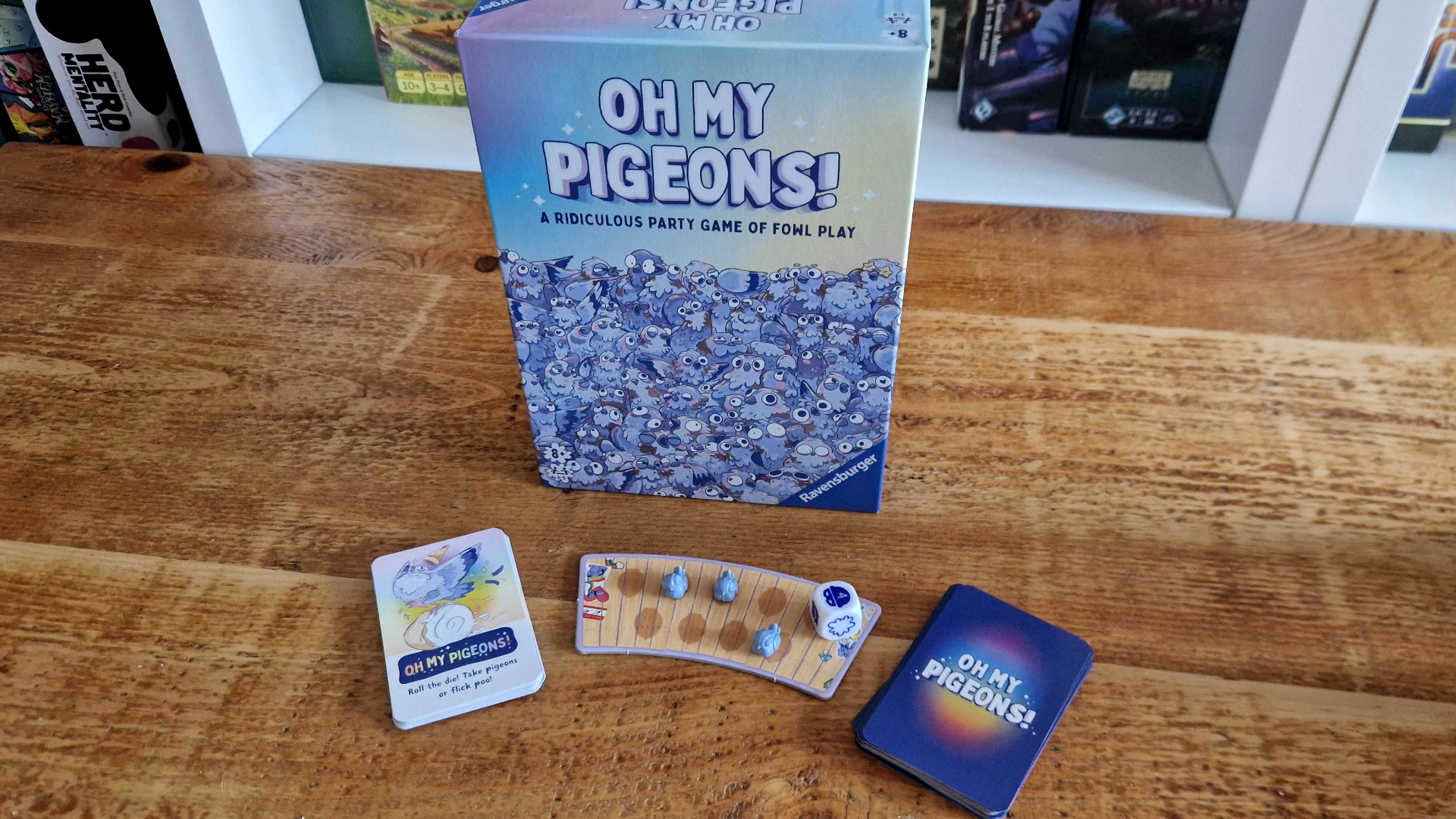 Oh My Pigeons box, cards, tokens, and board on a wooden table