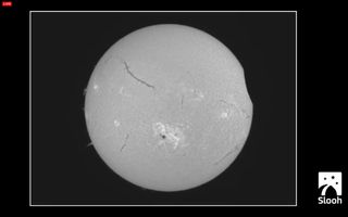 The partial solar eclipse of Oct. 23, 2014, begins, as seen by the Slooh online telescope, presented on their live webcast.