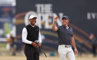 Rory and Tiger smile as they walk down the 18th
