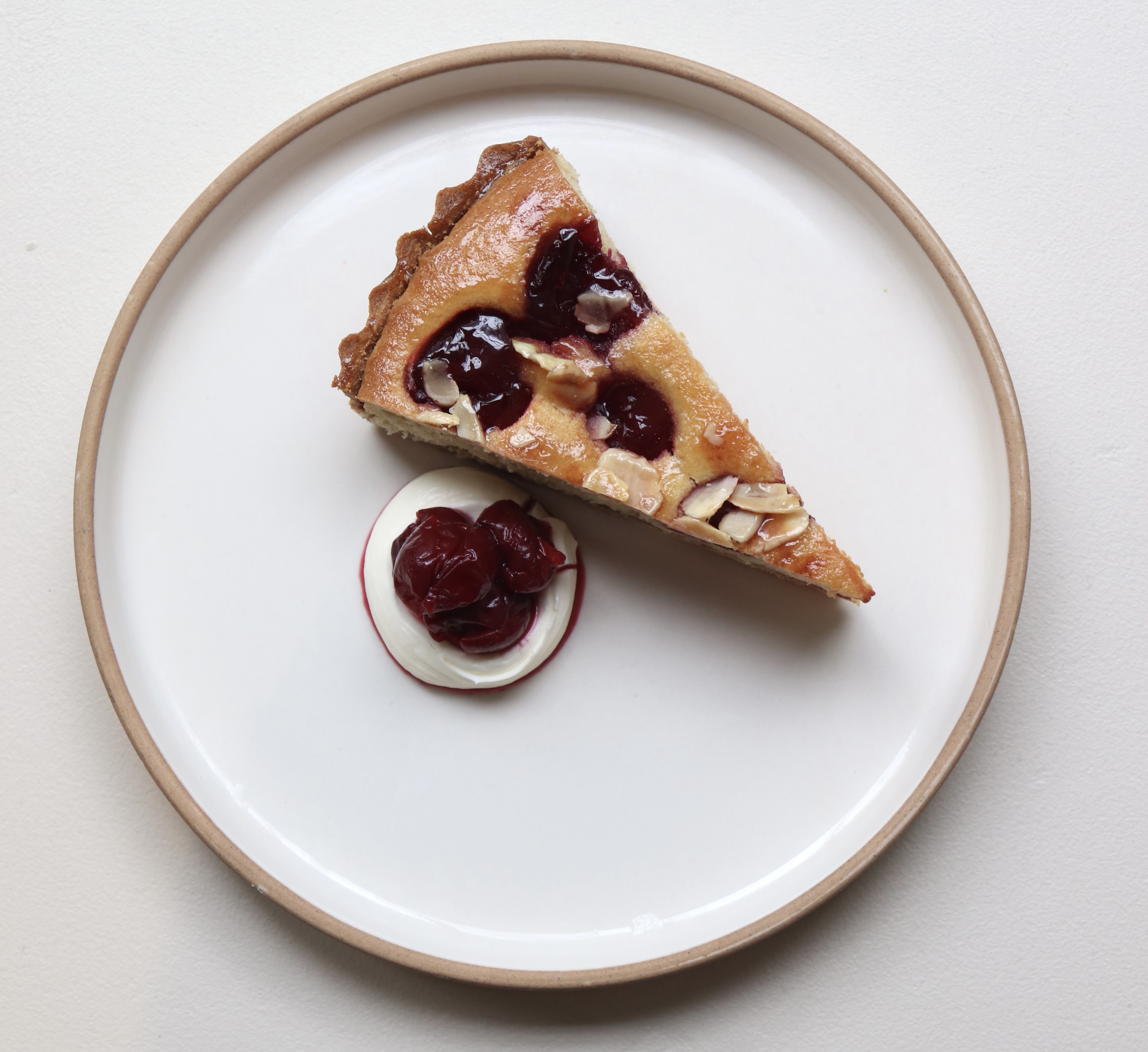 Slice of cherry tart on a white plate