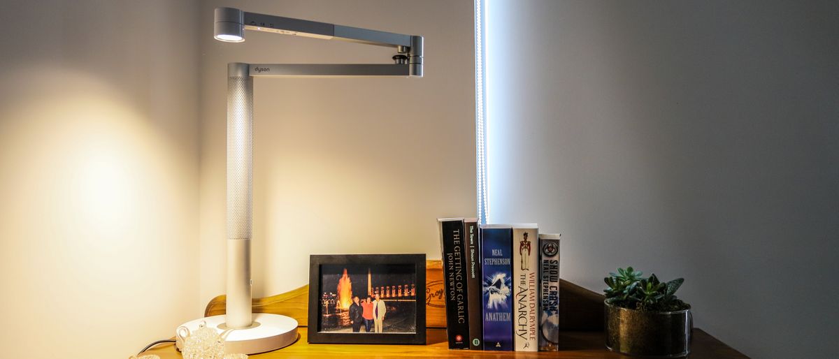 Dyson Solarcycle Morph Desk on a table beside some books and a photograph