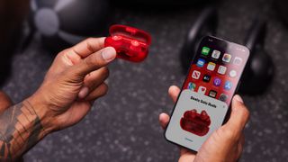 The Beats Solo Buds next to an iPhone in a gym setting.