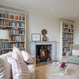 white living room with book shelfs and fire place