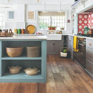 A kitchen with open cookware storage with Le Creuiset cast iron casseroles