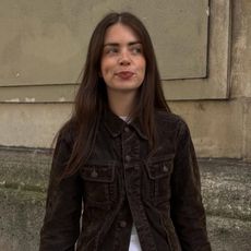 a woman wearing a brown jacket