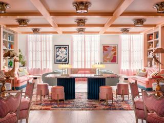 The pink-shaded interiors of a hotel feature multiple Art Deco accents and a retro-futuristic, candyfloss atmosphere.