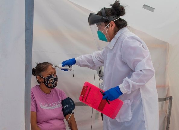 A medic takes a patient&amp;#039;s temperature in Arizona.