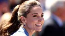 Catherine, Princess of Wales is pictured smiling, with her hair up in a ponytail, as she attends on day four of The Championships Wimbledon 2026 at All England Lawn Tennis and Croquet Club on July 02, 2026 in London, England. 