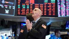 Stockbroker with hands clasped in prayer