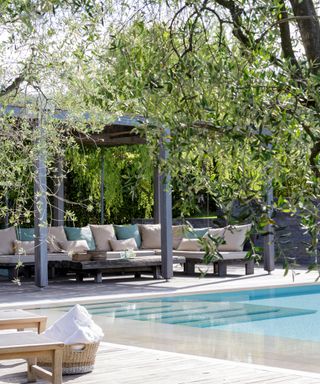 pergola with chairs by swimming pool