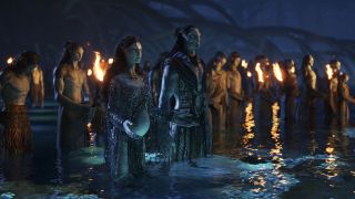 Kate Winslet's Ronal and Sam Worthington's Jake Sully surrounded by other Na'vi in Avatar: The Way of Water