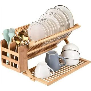 A wooden dish drying rack filled with plates, mugs and cutlery