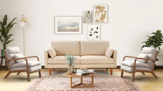 a living room with a small couch, two accent chairs, a small coffee table, and an arrangement of photos on the wall