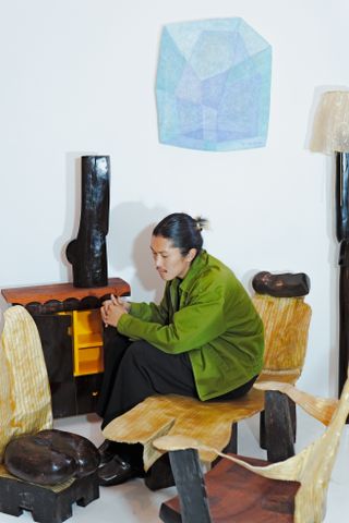 Designer Minjae Kim in his studio surrounded by pieces from the exhibition at Marta Los Angeles including chaise longue, cabinet and wall piece in light blue