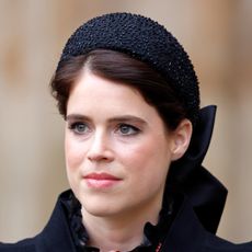 Princess Eugenie wearing a black hat, King Charles and Prince Harry wearing suits