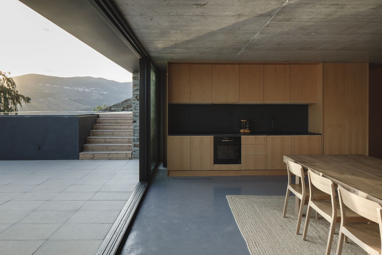 The middle level includes the kitchen and dining area, opening out onto the pool terrace