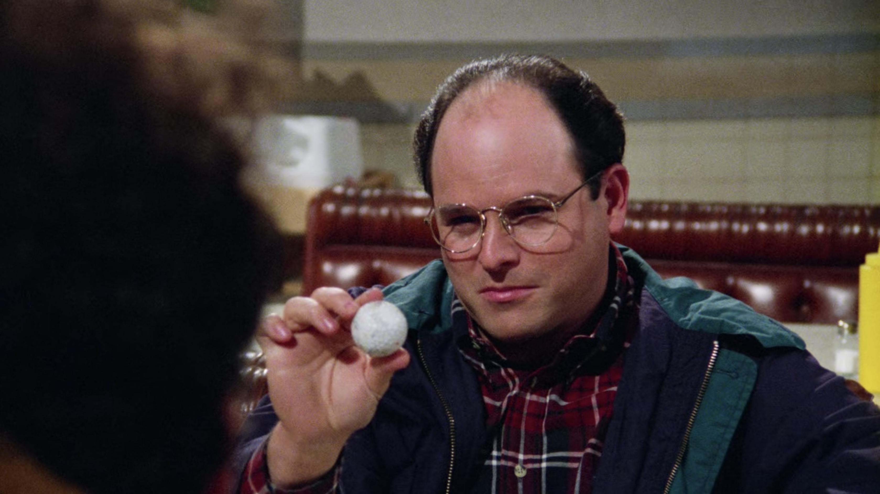 George Costanza holding a golf ball in The Marine Biologist, one of the best seinfeld episodes