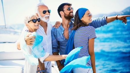 Family at yacht cruse standing and looking at beautiful view.