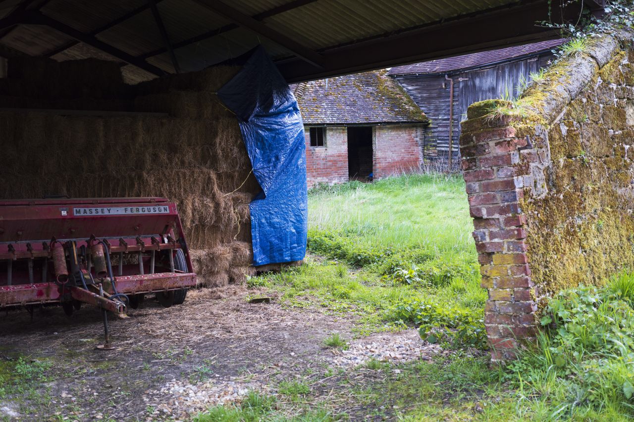 The inside of a barn looking out over a field