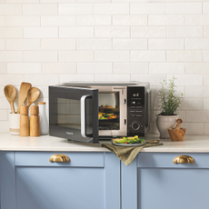 Aldi microwave air fryer on a white kitchen side with pale blue cupboards.