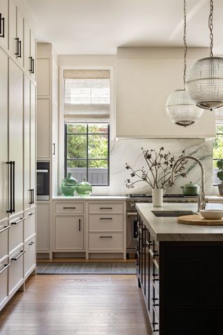 kitchen with off-white cabinets, oak island and white marble countertops