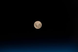 The Blue Moon looms high above the thin blue veil of Earth's atmosphere in this photo captured by an astronaut at the International Space Station on May 18, 2019.