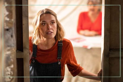 a still of Sally Bretton looking out a door in Beyond Paradise