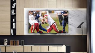 The LG B8 OLED TV in a modern living room displaying an NFL football game