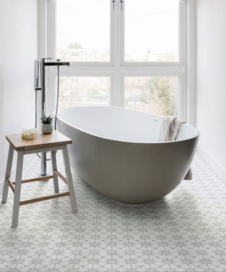 Grey freestanding bath in light bathroom