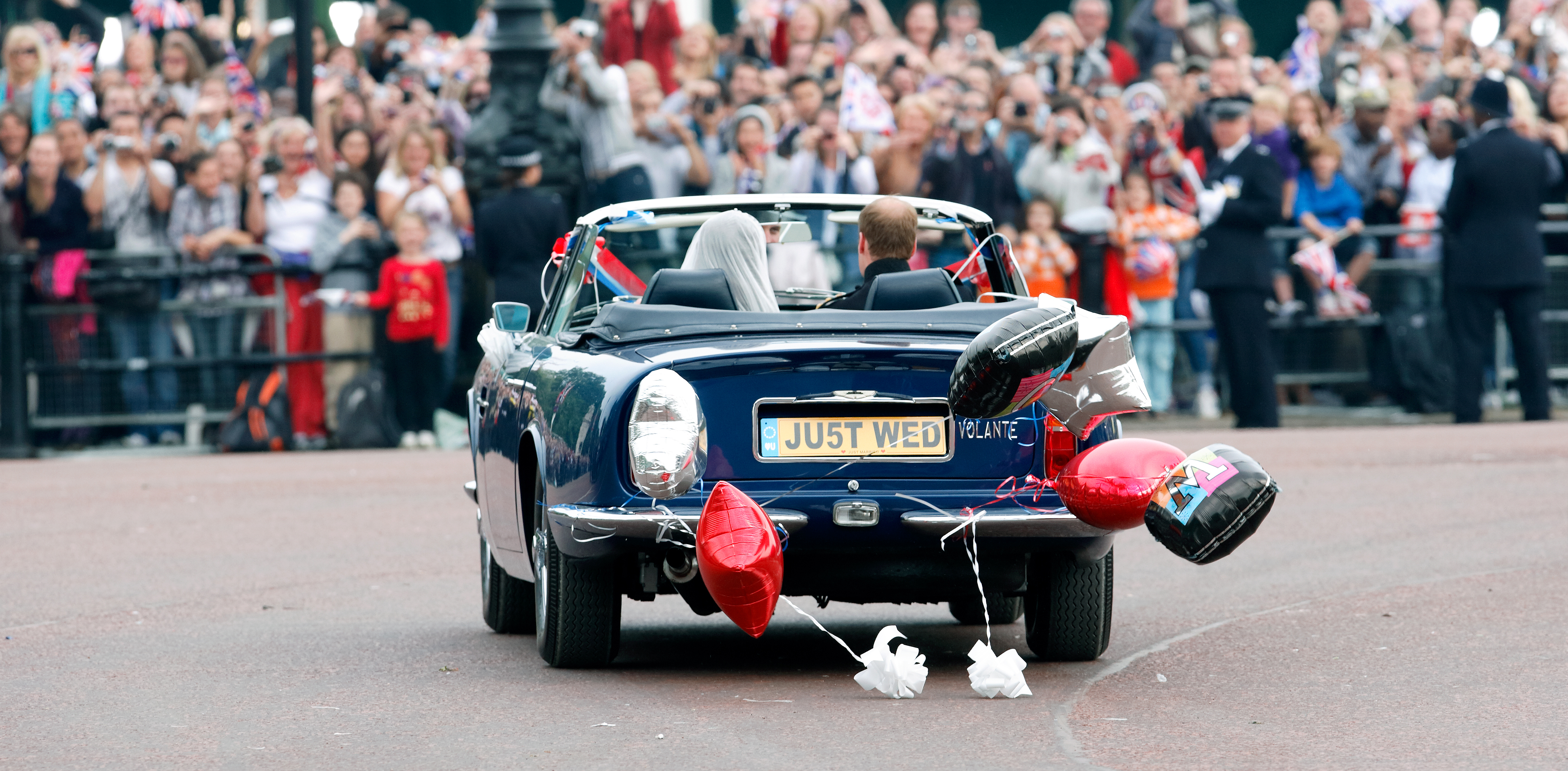 Prince William and Princess Kate driving in King Charles's Aston Martin convertible on their wedding day