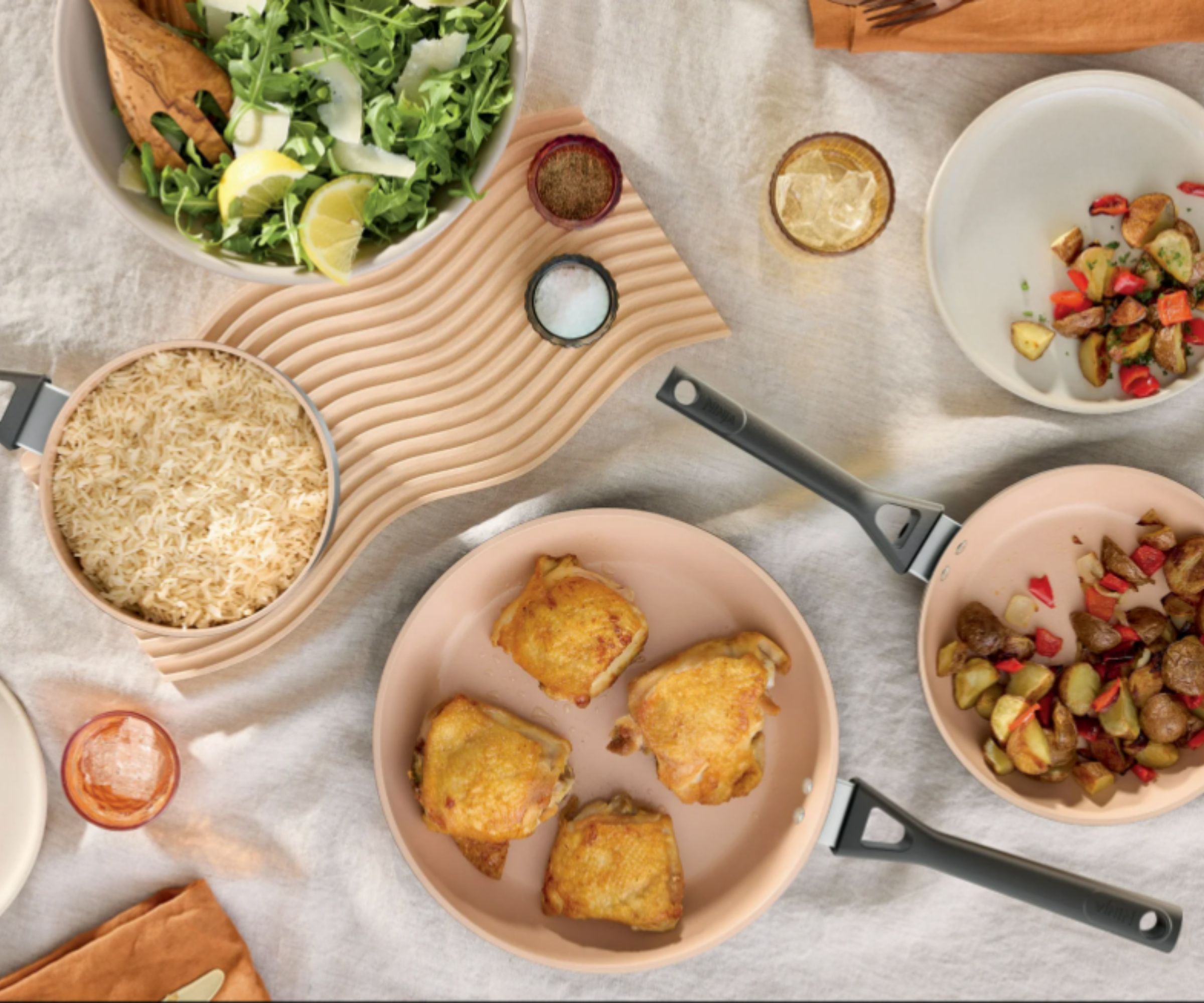 Ninja ceramic pans in pale pink with food in on a table