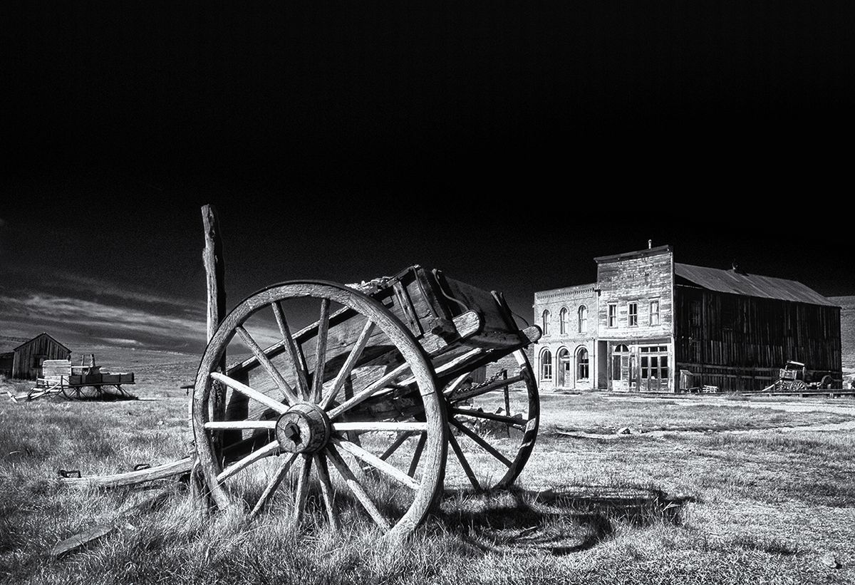 Black and white pic of old cart in front of wild west town