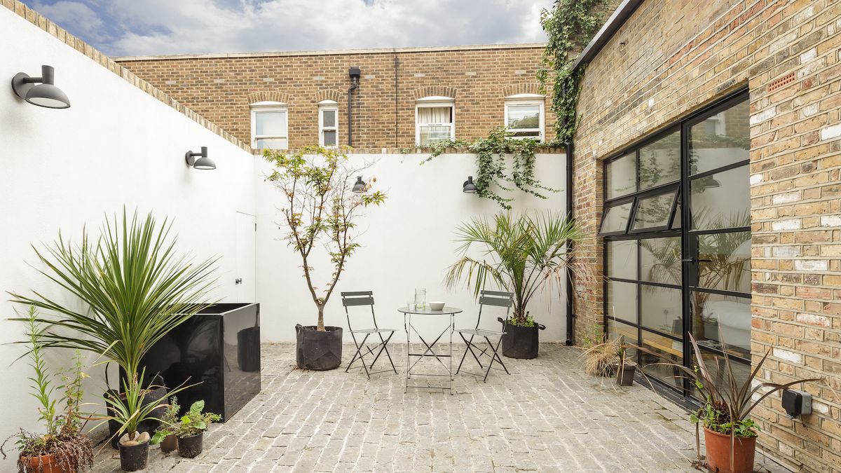 simple brick patio with small table and trees