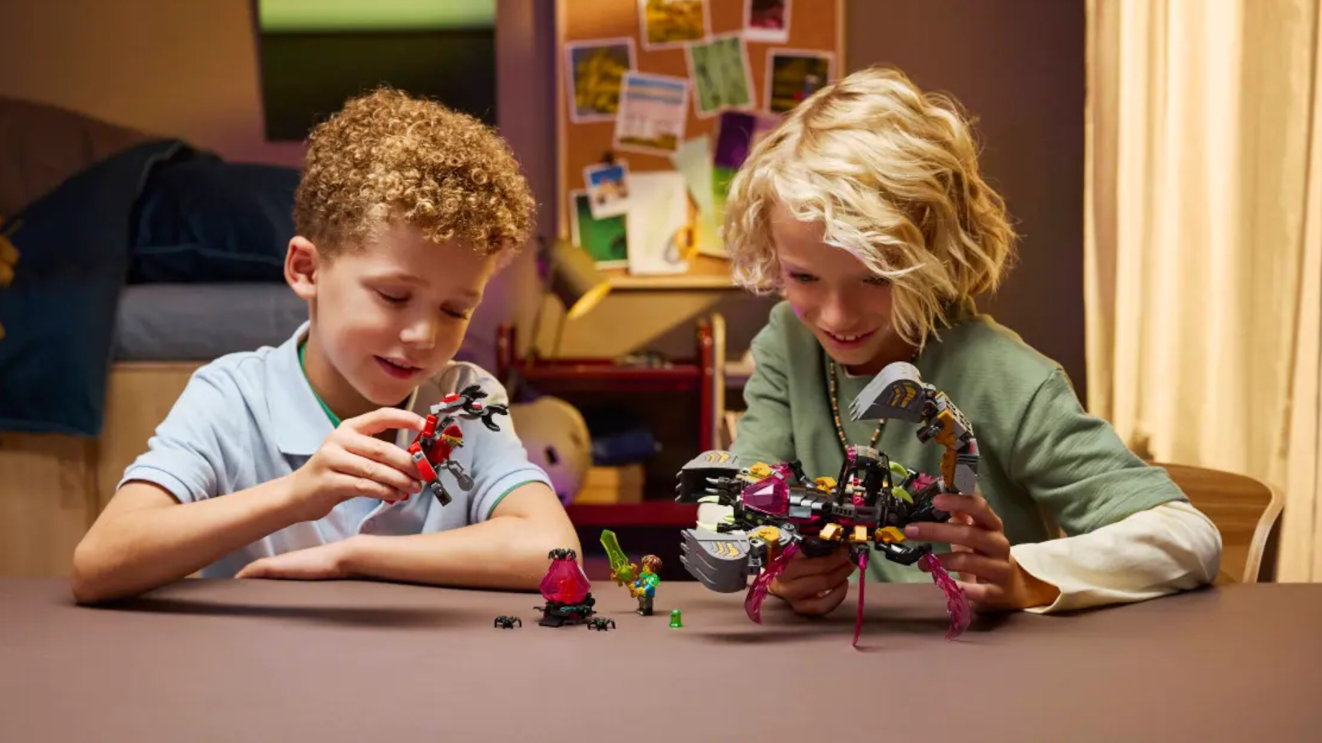 Two children play with a Lego robot scorpion on a table