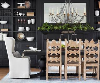 Dining room with black walls, wooden seating and candelabra