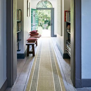 long hallways leating out to a front door striped runner hallway bench