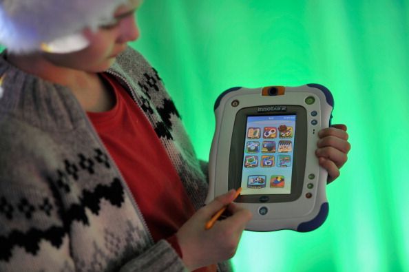 A child holds a VTech toy.