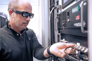 A Vodafone engineer is working on a server using Eyes in the Lab glasses