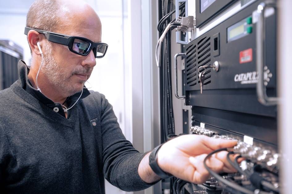 A Vodafone engineer is working on a server using Eyes in the Lab glasses