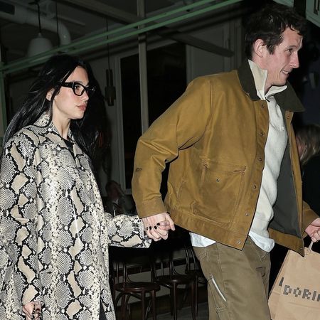 Dua Lipa holds hands with rumored fiance Callum Turner while wearing a snakeskin trench coat and carrying a Chanel 25 handbag