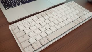 A white Logitech MX Keys Mini for Mac keyboard sitting on a desk