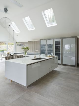 white kitchen island with inset plinth to give the appearance of it floating