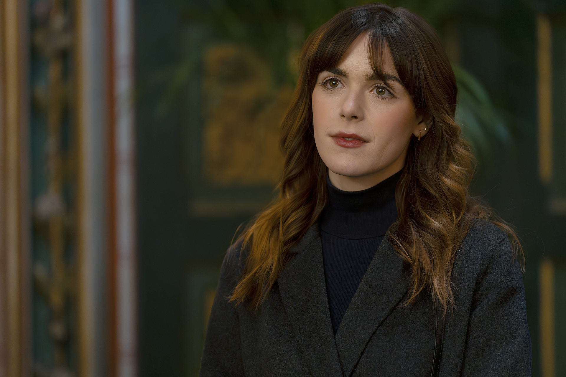 kiernan shipka in a new role in industry season 4 with long brown hair and bangs and waring a blazer