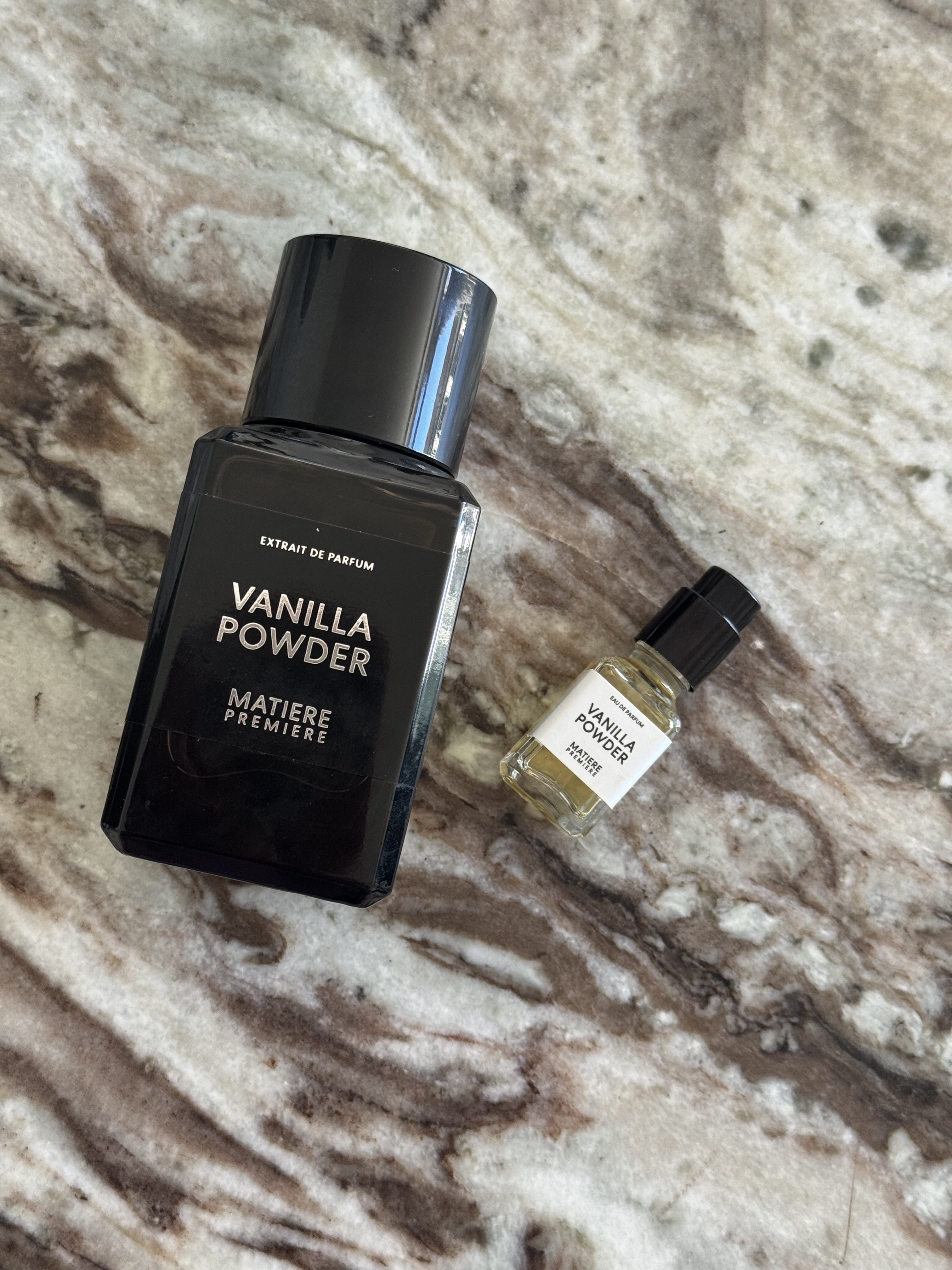 Matiere Premiere Vanilla Powder extrait perfume bottle and a mini vanilla powder eau de parfum bottle on a marble table